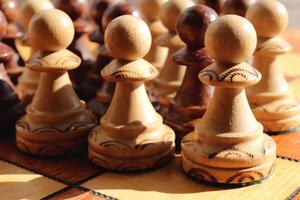 Many white and black pawns figures stand on a chess board. Wood game chessboard background. photo