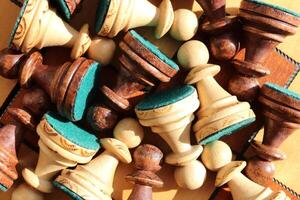 A lot of chess figures lies on a chess board. Wood game chessboard background. photo