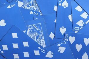 Mixed playing cards background. Assorted play cards backdrop. Many miscellaneous jumbled blue playing cards surface. photo