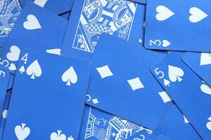 Assorted play cards backdrop. Many miscellaneous jumbled blue playing cards surface. Mixed playing cards background. photo