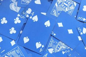 Many miscellaneous jumbled blue playing cards surface. Mixed playing cards background. Assorted play cards backdrop. photo