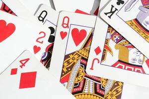 Assorted play cards backdrop. Many miscellaneous jumbled playing cards surface. Mixed playing cards background. photo