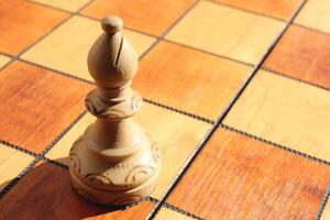 The figure of a white elephant stands on a chess board. Wood game chessboard background. photo