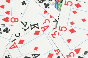 Mixed playing cards background. Assorted play cards backdrop. Many miscellaneous jumbled playing cards surface. photo