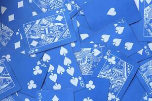 Mixed playing cards background. Assorted play cards backdrop. Many miscellaneous jumbled blue playing cards surface. photo