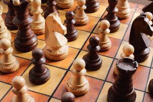 A lot of chess figures stands on a chess board. Wood game chessboard background. photo