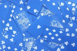 Mixed playing cards background. Assorted play cards backdrop. Many miscellaneous jumbled blue playing cards surface. photo
