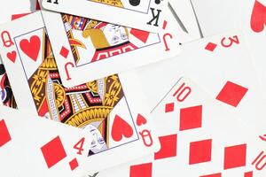 Many miscellaneous jumbled playing cards surface. Mixed playing cards background. Assorted play cards backdrop. photo