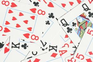 Many miscellaneous jumbled playing cards surface. Mixed playing cards background. Assorted play cards backdrop. photo