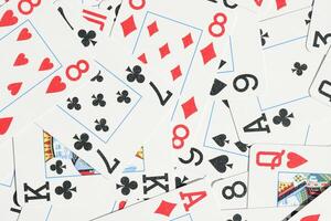 Mixed playing cards background. Assorted play cards backdrop. Many miscellaneous jumbled playing cards surface. photo