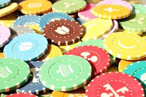Many colored chips backdrop. Lot multicolor assorted gambling playing chips surface. Colorful casino chips background. photo