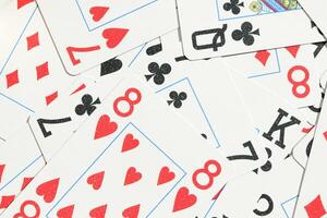 Mixed playing cards background. Assorted play cards backdrop. Many miscellaneous jumbled playing cards surface. photo