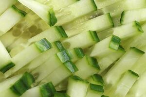 Cucumber chopped slices filling texture. Diet salad pieces background. photo