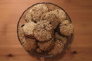 Bowl of fresh date biscuits cookie sprinkled with sesame seeds photo