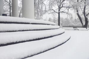 Pavilion under the flag round steps under a thick layer of snow. Landscape of winter park. photo