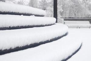 Pavilion under the flag round steps under a thick layer of snow. Landscape of winter park. photo