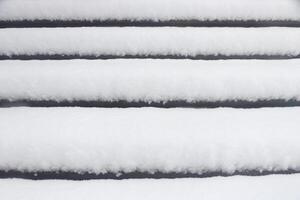 Pavilion under the flag round steps under a thick layer of snow. Landscape of winter park. photo