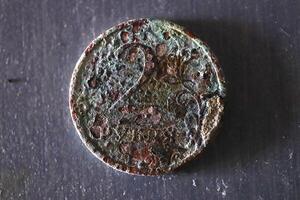 Rusty two ruble coin on a white painted wooden surface photo