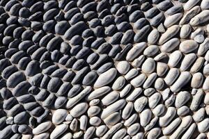 Lot of white masonry cladding pebble texture. Stones pattern background. photo