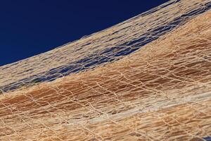 Nylon fishnet texture on the clear sky. Nautical marine background. Macro closeup. photo
