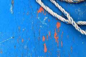 Blue painted wood texture with rope. Weathered paint wooden board. Natural wood structure background. photo