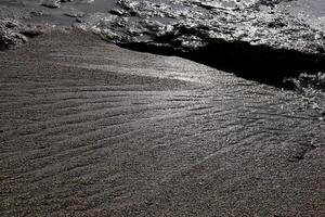 Sand and cliff water stock texture. Summer beach background. photo