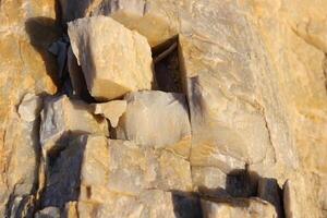 Sunny rough bust fractured stone texture material macro closeup. photo