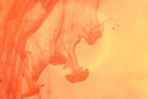 Orange Ink Drops in Water. Liquid Fantasy Art Splashes. Abstract Background. photo