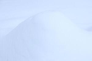 Snowy mound texture. Winter snowdrift landscape background. Soft snow hills surface. photo