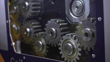 Mechanism with rotating gears. Media. Shiny metal gears rotate in moving mechanism. Industrial mechanism with rotating gears photo
