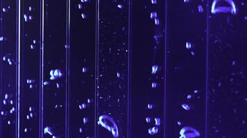 Close up of underwater view of air bubbles in colored liquid substance. Clip. Vertical bubbles flow in water. photo