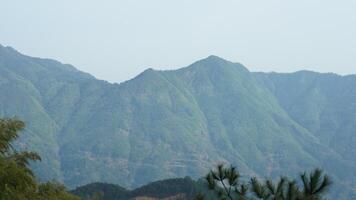 The beautiful mountains landscapes with the green forest and the erupted rock cliff as background in the countryside of the China photo