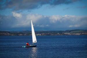 Sailboat is sailing in the Lake under a blue sky photo