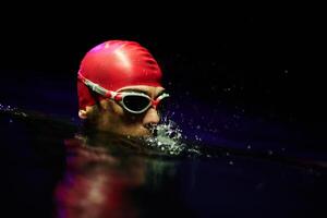 A determined professional triathlete undergoes rigorous night time training in cold waters, showcasing dedication and resilience in preparation for an upcoming triathlon swim competition photo