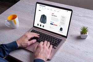 Shopping for men's blazers online, exploring various colors, using a laptop on an e-commerce platform for a seamless experience photo