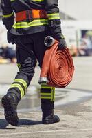 In a dynamic display of synchronized teamwork, firefighters hustle to carry, connect, and deploy firefighting hoses with precision, showcasing their intensive training and readiness for challenging photo