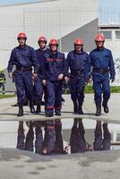 A team of confident and accomplished firefighters strides purposefully in their uniforms, exuding pride and satisfaction after successfully completing a challenging firefighting mission photo