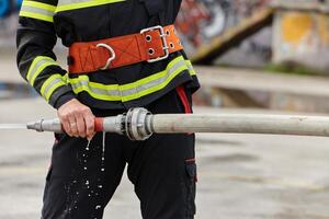 In a dynamic display of synchronized teamwork, firefighters hustle to carry, connect, and deploy firefighting hoses with precision, showcasing their intensive training and readiness for challenging photo