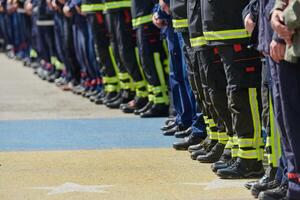 A group of firefighters lined up, saluting the flag, applauding in solidarity, and gearing up for intensive training sessions, showcasing their unwavering commitment to service and teamwork. photo