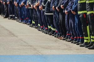A group of firefighters lined up, saluting the flag, applauding in solidarity, and gearing up for intensive training sessions, showcasing their unwavering commitment to service and teamwork. photo