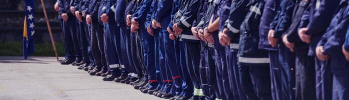 A group of firefighters lined up, saluting the flag, applauding in solidarity, and gearing up for intensive training sessions, showcasing their unwavering commitment to service and teamwork. photo