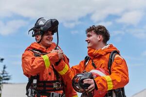 A unified team of firefighters, adorned in their uniforms, engages in a heartfelt celebration marked by triumphant salutes and cheers, embodying the joy and gratitude following the successful photo
