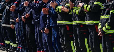 un grupo de bomberos forrado arriba, saludando el bandera, aplaudiendo en solidaridad, y engranaje arriba para intensivo formación sesiones, exhibiendo su inquebrantable compromiso a Servicio y trabajo en equipo. foto