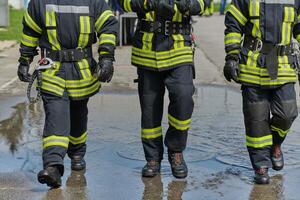 A team of confident and accomplished firefighters strides purposefully in their uniforms, exuding pride and satisfaction after successfully completing a challenging firefighting mission photo