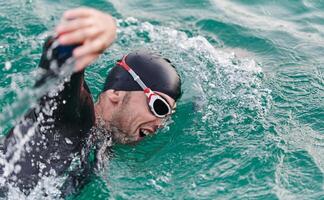 A professional triathlete trains with unwavering dedication for an upcoming competition at a lake, emanating a sense of athleticism and profound commitment to excellence. photo