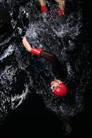 A determined professional triathlete undergoes rigorous night time training in cold waters, showcasing dedication and resilience in preparation for an upcoming triathlon swim competition photo