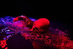 Authentic triathlete swimmer having a break during hard training on night neon gel light photo