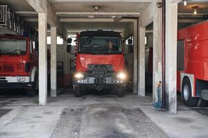 A dedicated firefighter preparing a modern firetruck for deployment to hazardous fire-stricken areas, demonstrating readiness and commitment to emergency response photo