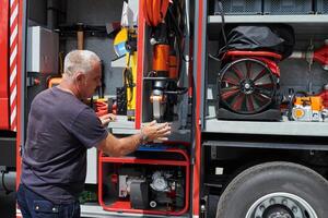 A dedicated firefighter preparing a modern firetruck for deployment to hazardous fire-stricken areas, demonstrating readiness and commitment to emergency response photo