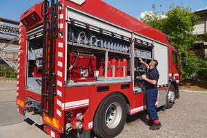 A dedicated firefighter preparing a modern firetruck for deployment to hazardous fire-stricken areas, demonstrating readiness and commitment to emergency response photo